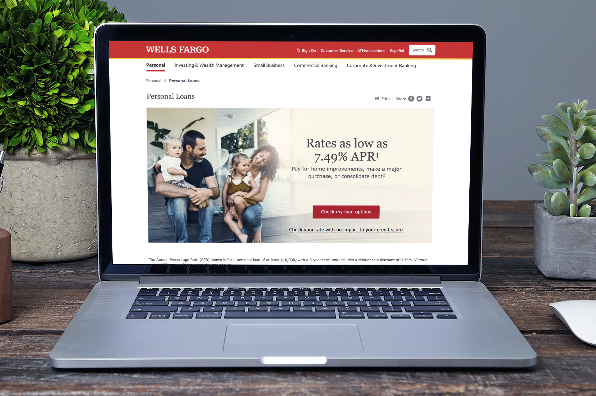 Photo of a laptop on a desk, with a webpage on the screen. The webpage is for Personal Loans, and shows a young family at home, with marketing copy to the right.