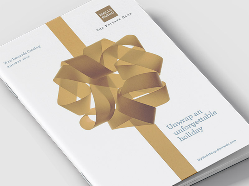 The front cover of a holiday catalog. The cover is white with a gold bow and ribbon, appearing to be wrapped like a gift.