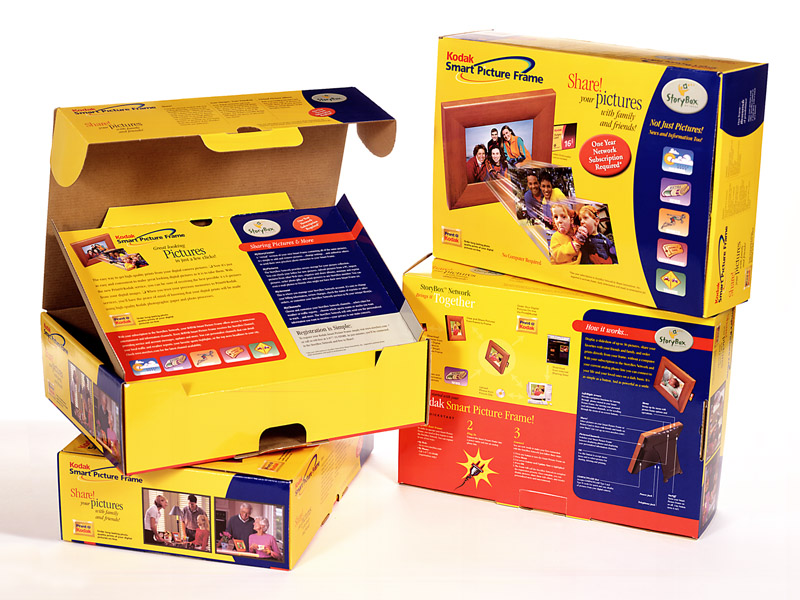 Photo of a digital picture frame product packaging, showing the front and back of the box, and inside the box with the top lid open.